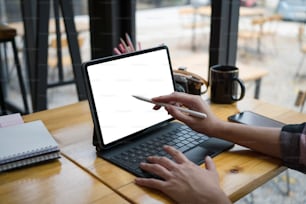 디지털 태블릿 화면을 가리키는 스타일러스 펜을 들고 있는 여성 디자이너의 클로즈업 뷰.