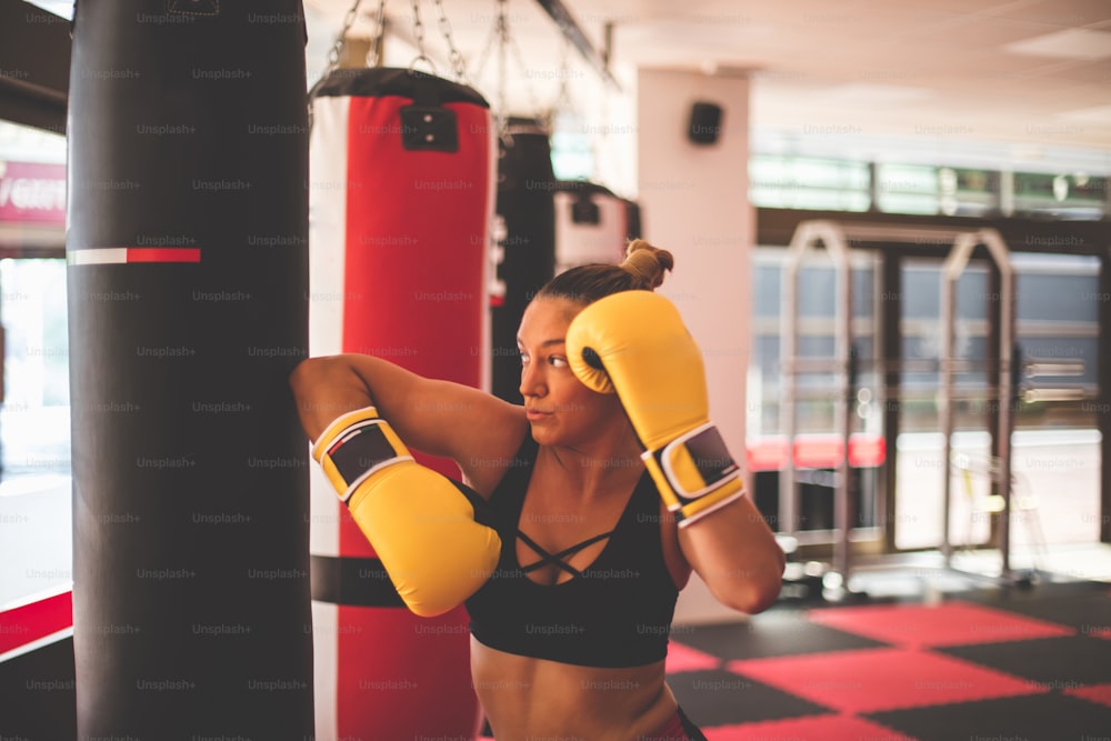 Woman boxer punching bag.