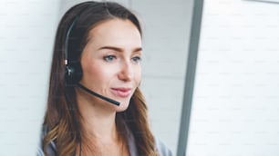 Business people wearing headset working in office to support remote customer or colleague. Call center, telemarketing, customer support agent provide service on telephone video conference call.