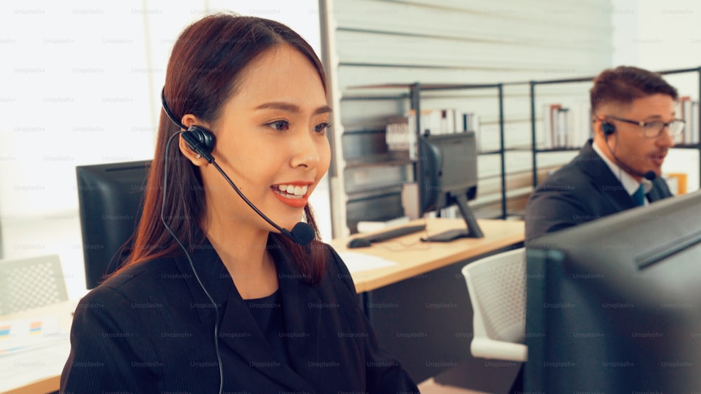 Des gens d’affaires portant un casque d’écoute travaillant au bureau pour soutenir un client ou un collègue à distance. Le centre d’appels, le télémarketing, l’agent de soutien à la clientèle fournissent un service par vidéoconférence téléphonique.