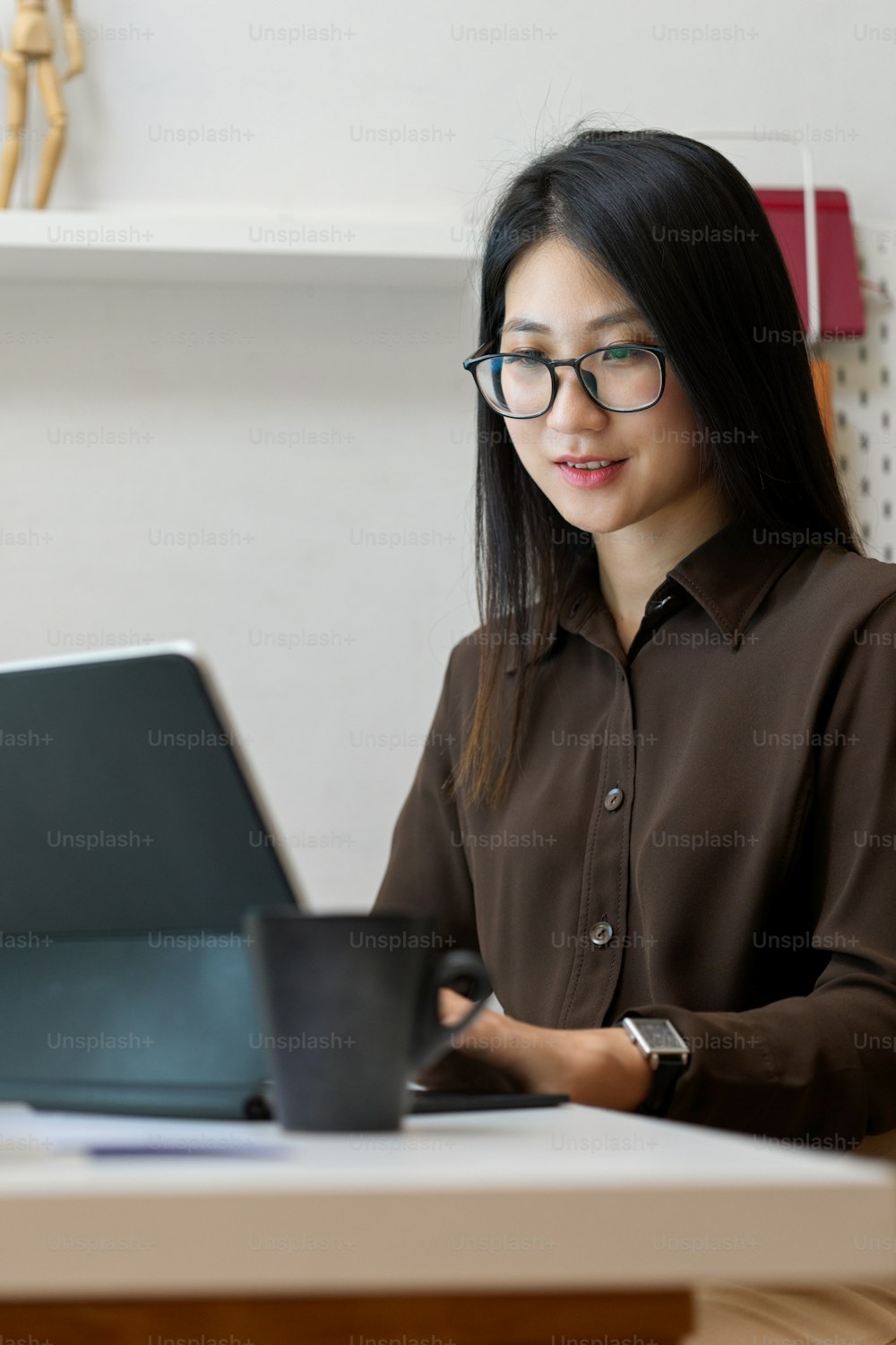 Ausschnittaufnahme einer jungen Büroangestellten bei der digitalen Tablet-Arbeit in einem komfortablen Büroraum