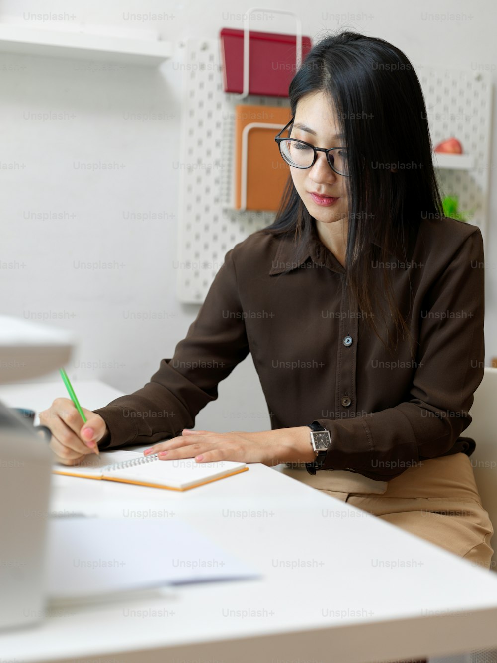 Portrait of female office worker working with stationery on office desk in comfortable office room