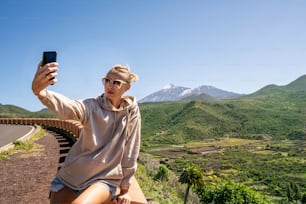 Junge Frau, die während ihrer Reise auf der Insel Selfies oder Vlogging auf dem Handy macht. Lifestyle-Reisen und Social Influencing-Konzept.