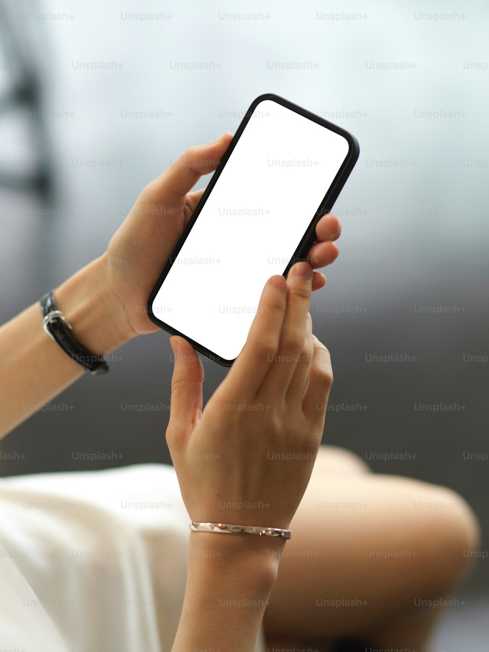 Cropped shot of female hand using smartphone include clipping path screen in blurred background