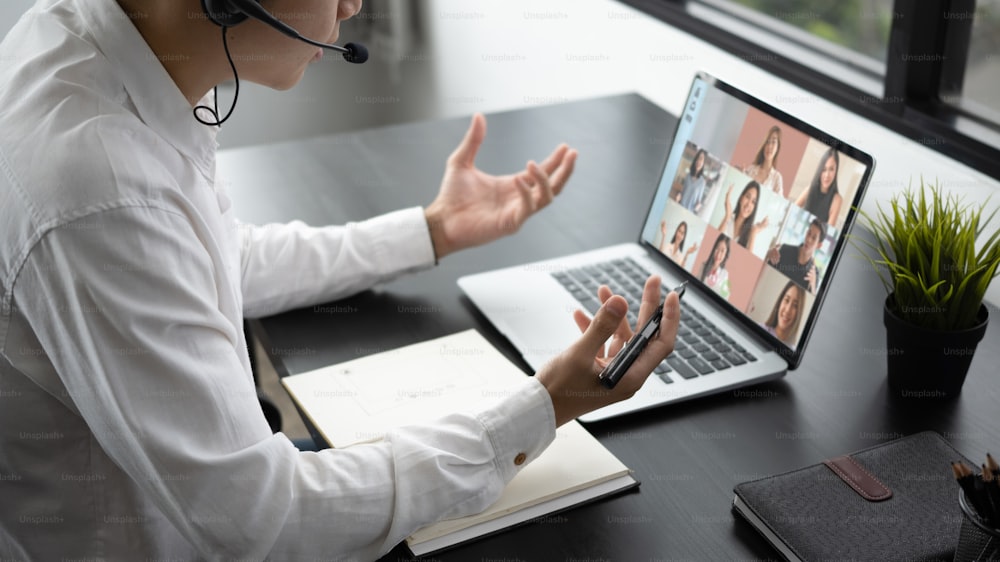 Cropped shot of businessman talking with diverse colleague team in video conference on computer laptop.