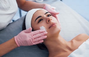 Close up view of woman that lying down in spa salon and have face cleaning procedure by the mask.