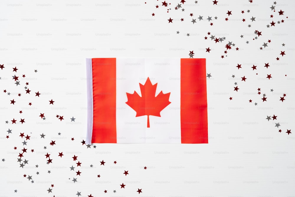Bandera de Canadá y confeti sobre fondo blanco. Concepto de feliz día de Canadá.