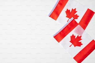 National flags of Canada on white background. Happy Canada Independence Day greeting card template. Flat lay, top view, copy space.