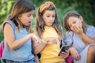 Vídeo chocante. Três meninas usando o telefone inteligente.