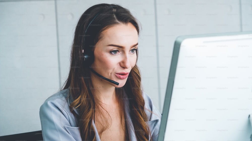 Business people wearing headset working in office to support remote customer or colleague. Call center, telemarketing, customer support agent provide service on telephone video conference call.