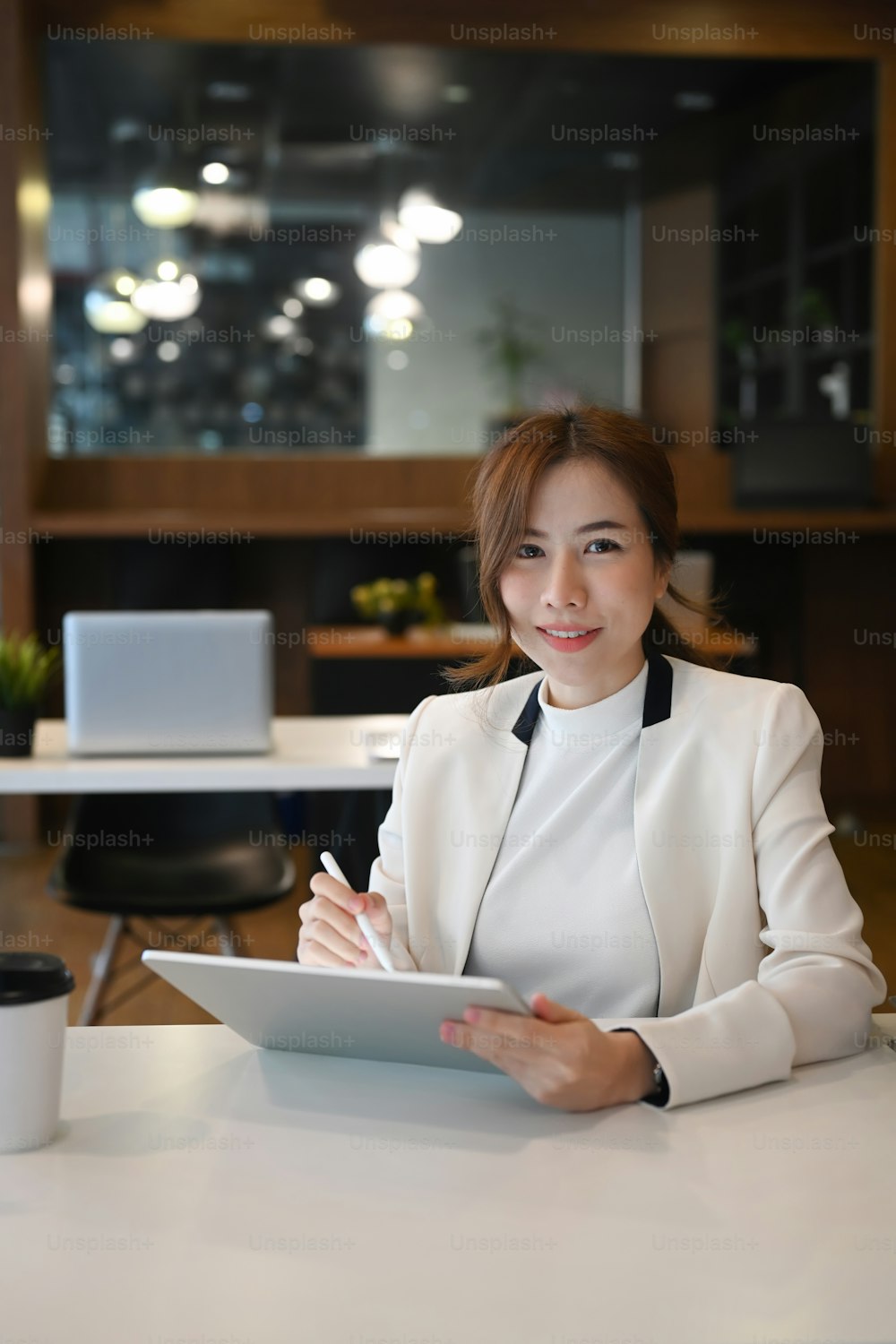 Retrato de una mujer de negocios exitosa sosteniendo una tableta digital y sonriendo a la cámara.