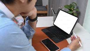 Cropped shot of businessman with headphone holding stylus pen and working with computer tablet.
