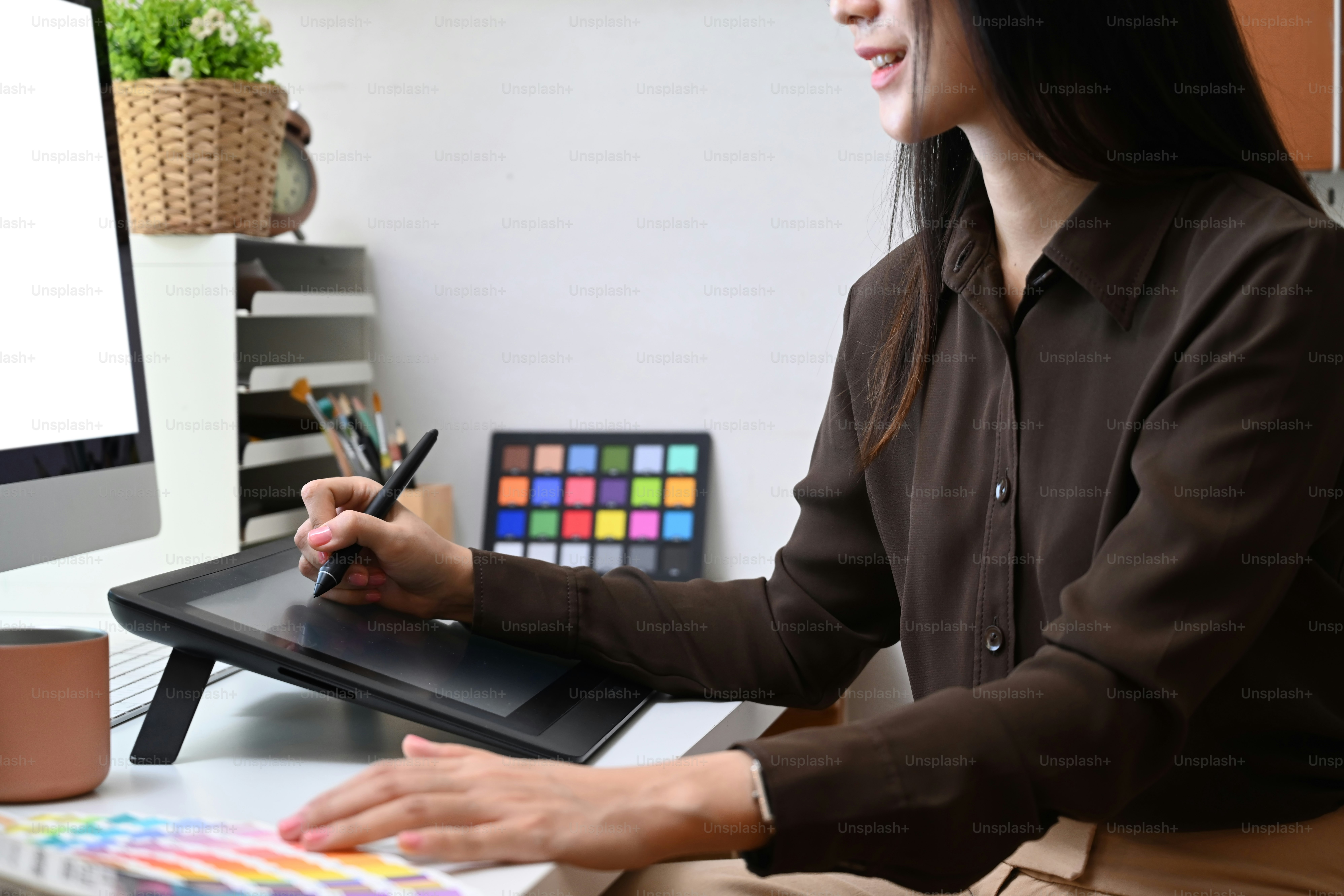 Cropped shot of young woman graphic designer choosing color samples for design project at creative office.