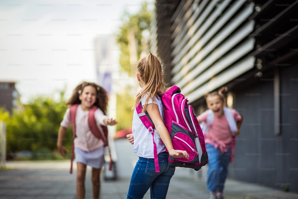 Three school girls outside. Focus is on foreground.