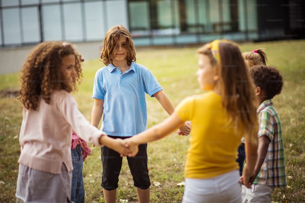 Large group of school kids having fun in nature. Focus is on background.