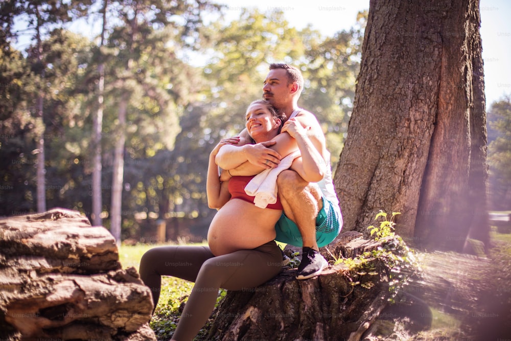 숲에서 웃는 남자와 임신한 여자.