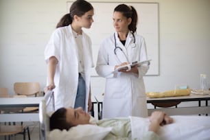 The doctor shows the student  patient's results. The doctor trains a young medical student.