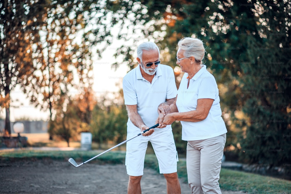 Couple de personnes âgées jouant au golf ensemble.