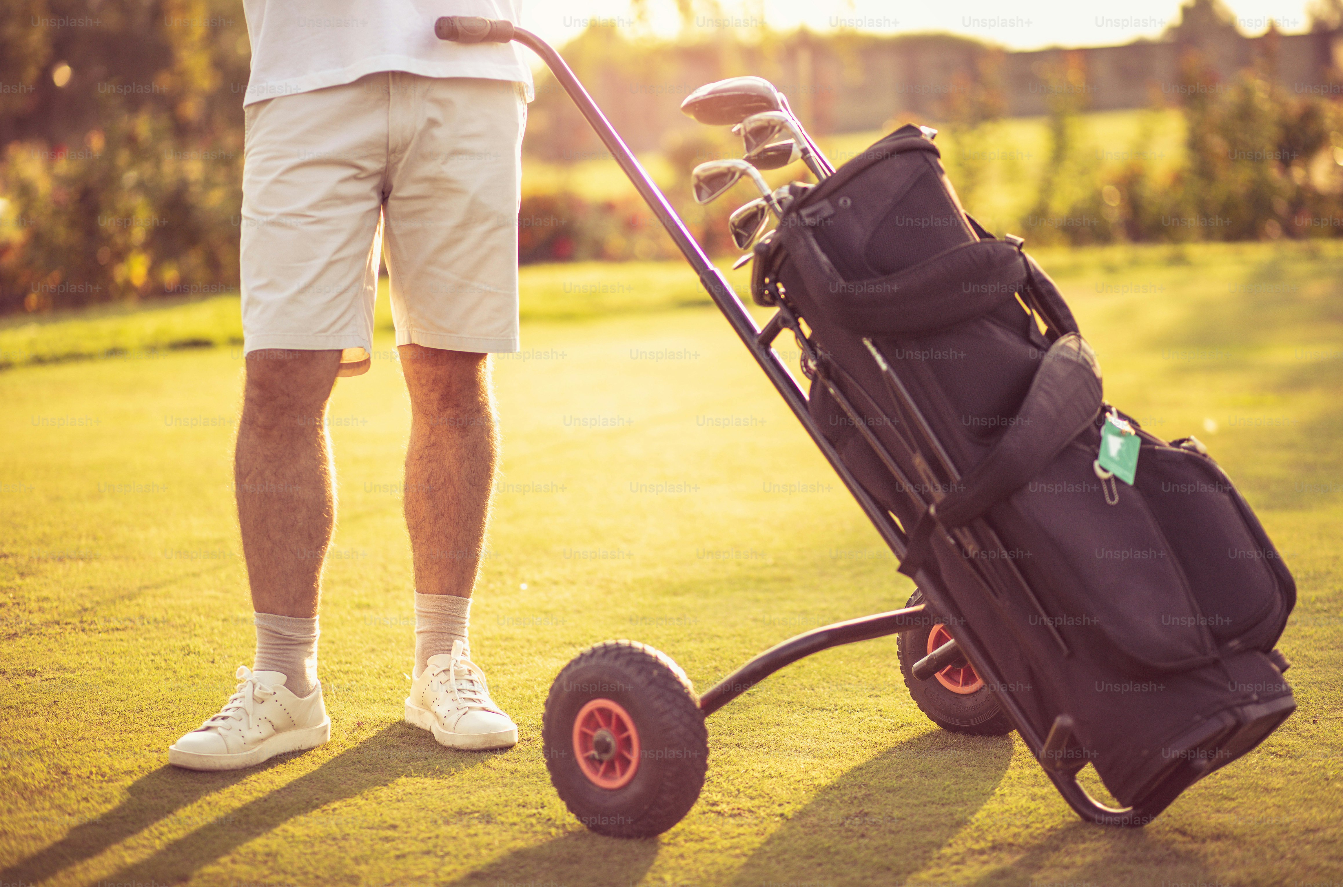Senior man standing on golf court. Golfer bag. Close up.