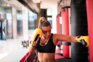 Woman boxer punching bag.