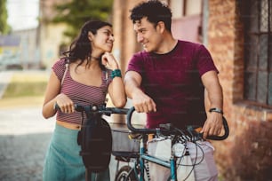 Young couple on the street with bike and electric scooter.