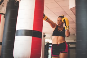 Woman boxer punching bag.