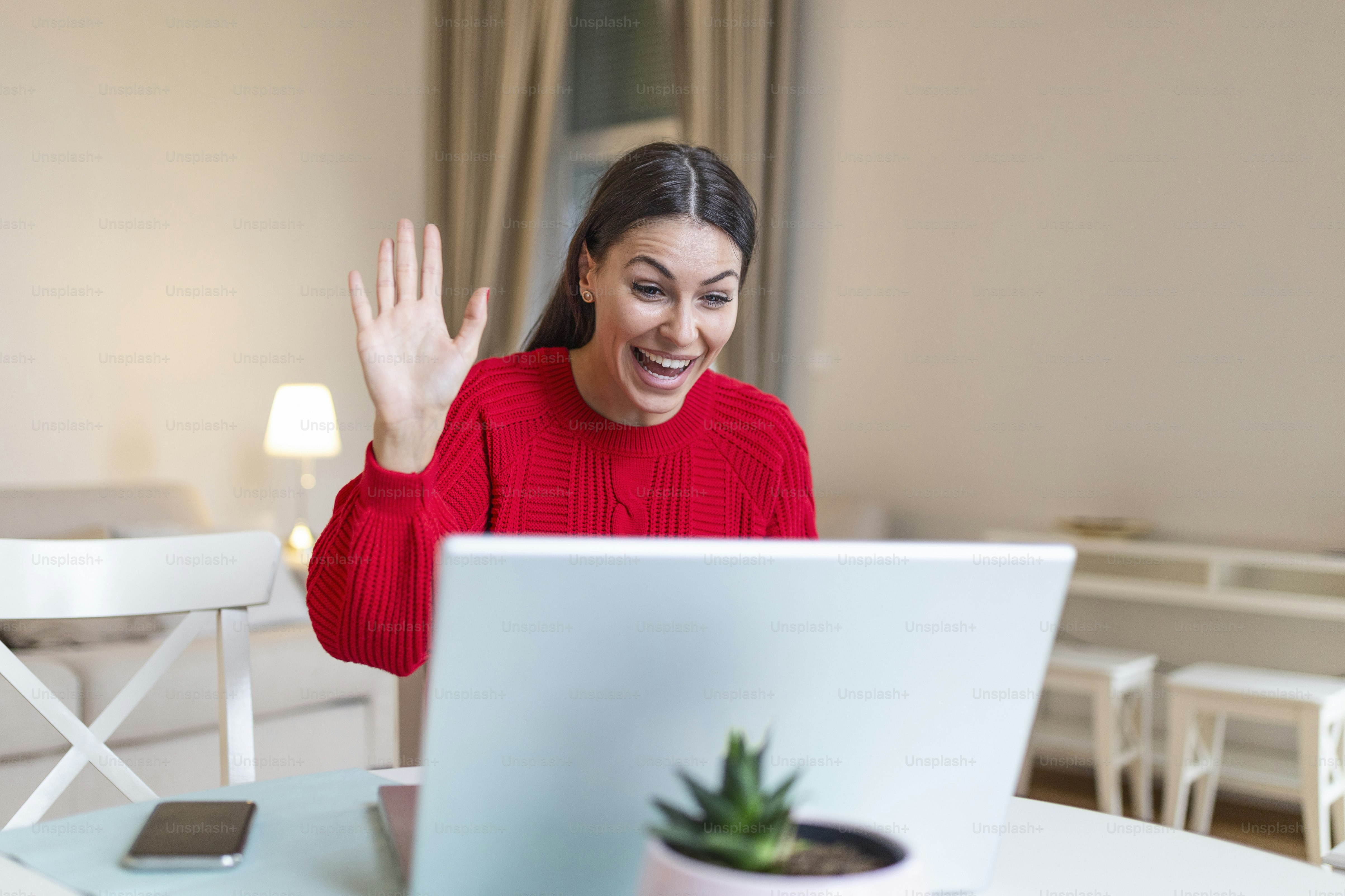 Young woman on a video call from home with her friends while in quarantine. Cropped shot of an attractive young woman using her laptop to make a video call at home
