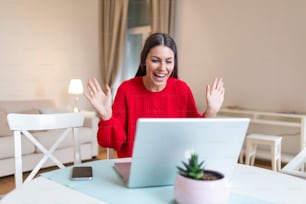 Young woman waving at laptop and talking to her friends via video call, girl student talking by video conference call, female teacher trainer tutoring by webcam, online training, e-coaching concept