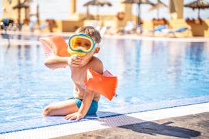어린이 스노클링. 여름 방학에 수영장에서 스노클링을 하는 어린 소년. 마스크를 쓴 아이.  다이빙을 배우는 어린 소년.