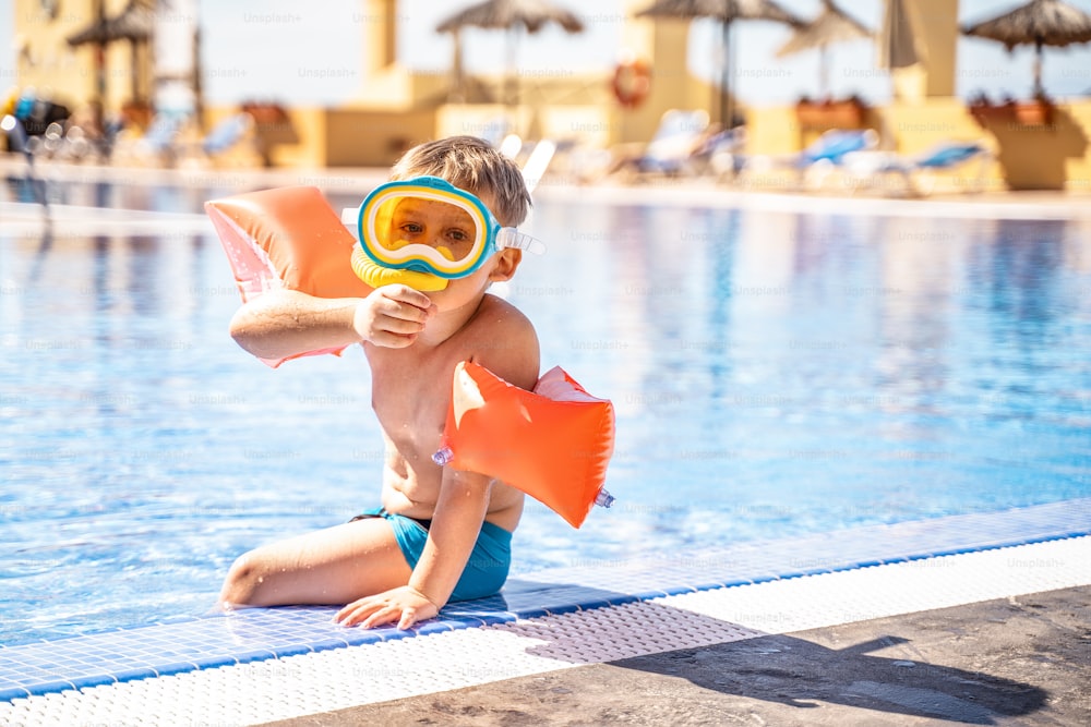 어린이 스노클링. 여름 방학에 수영장에서 스노클링을 하는 어린 소년. 마스크를 쓴 아이.  다이빙을 배우는 어린 소년.