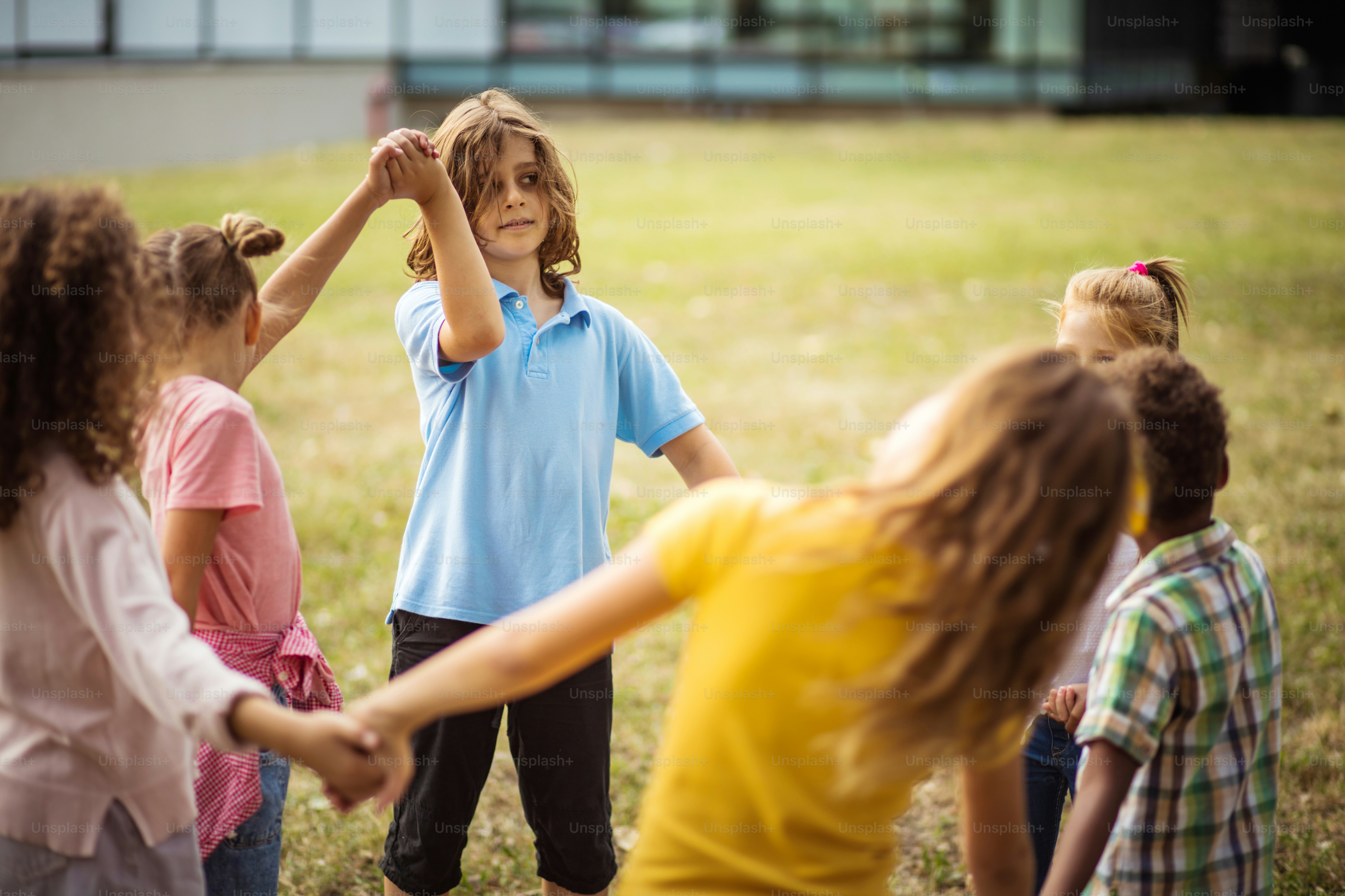 Large group of school kids having fun in nature. Focus is on background.