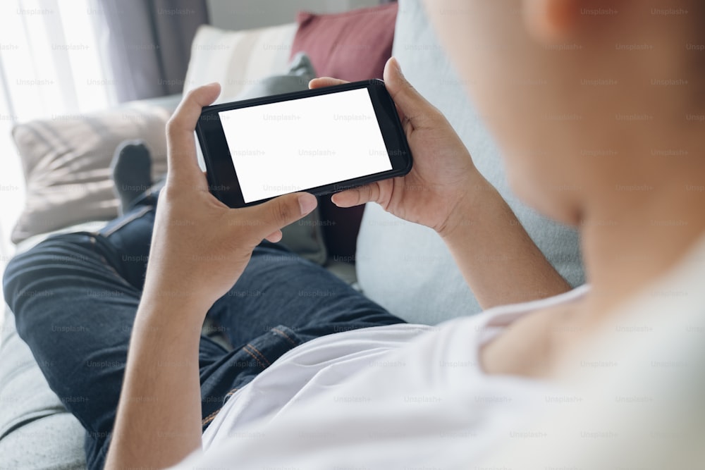 Close up of man hand holding smart phone. Blank screen mockup for graphics display montage.