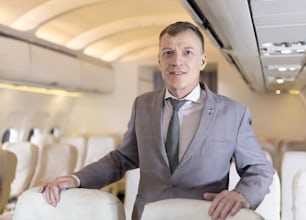 Retrato de hombre de negocios en un avión, pasajero que se relaja
