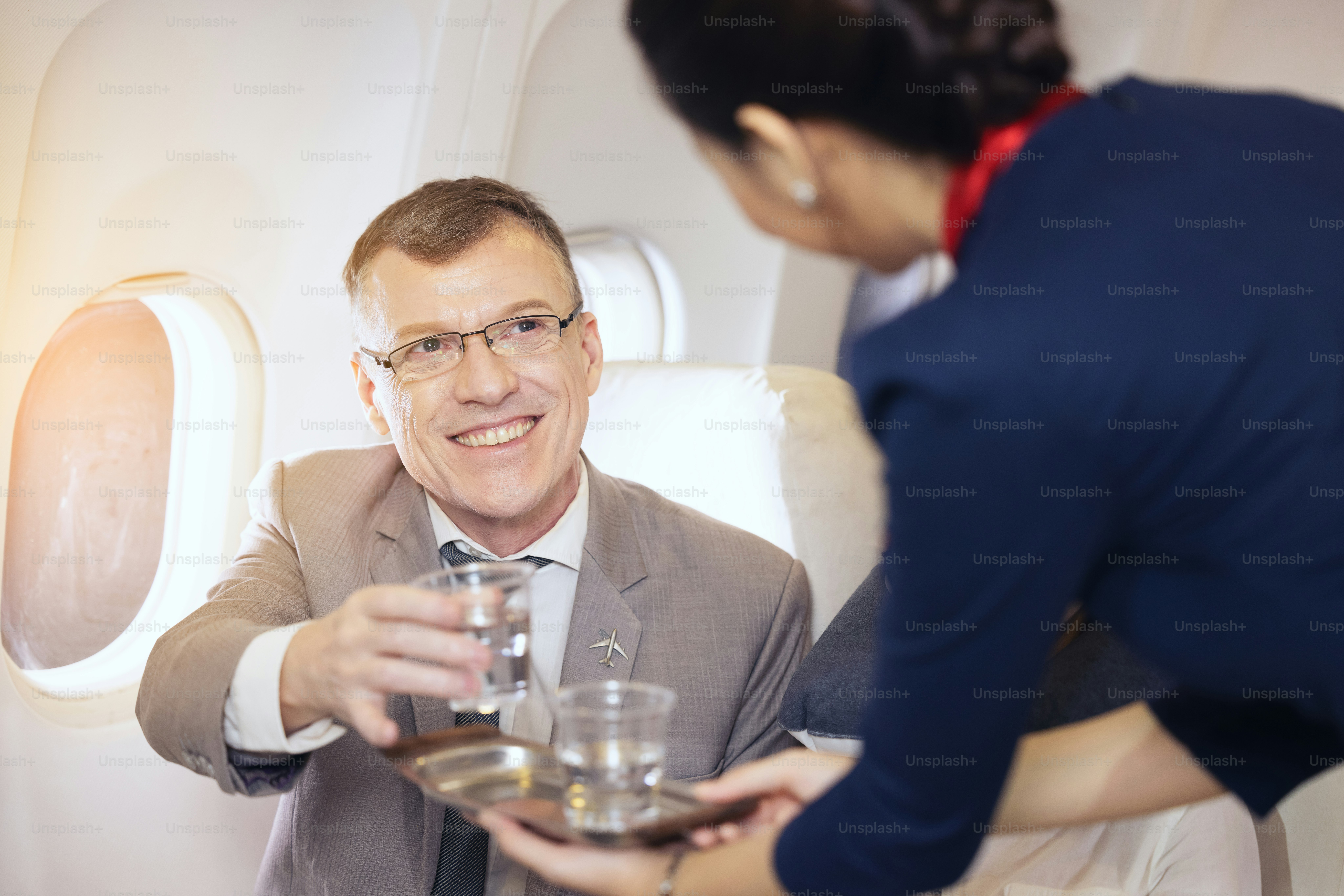 Passenger have water served by an air hostess in airplane, Flight attendants serve on board