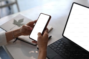 Close up view of businesswoman hands holding mock up smart phone with white screen.