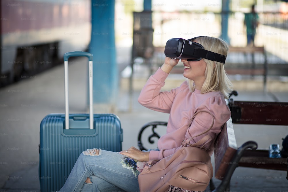 Virtual world. Young woman with VR helmet. Woman on train station.