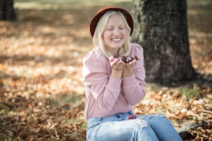 Woman in the park holding chestnuts.