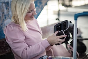 This is going to be fun. Young woman with VR helmet. Woman on bus station.