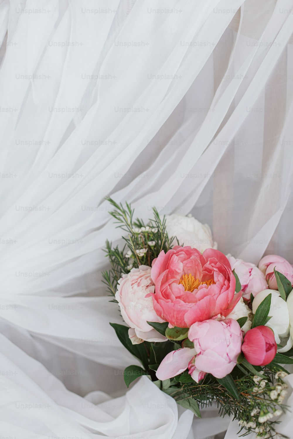 Bellissimo elegante bouquet di peonie su morbido tessuto bianco. Fiori di peonia rosa e bianchi su tulle su sedia rustica in legno. Buona festa della mamma. Mattina nuziale. Spazio per il testo