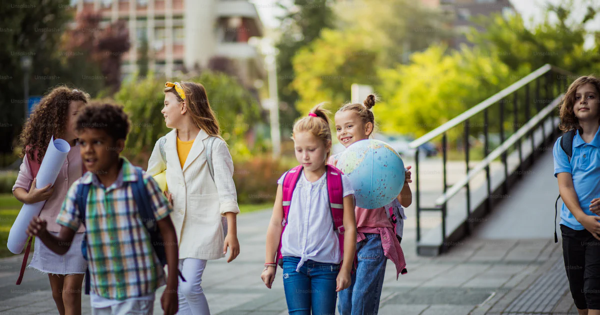 Groupe d’écoliers d’âge primaire à l’extérieur. Les écoliers vont à l ...