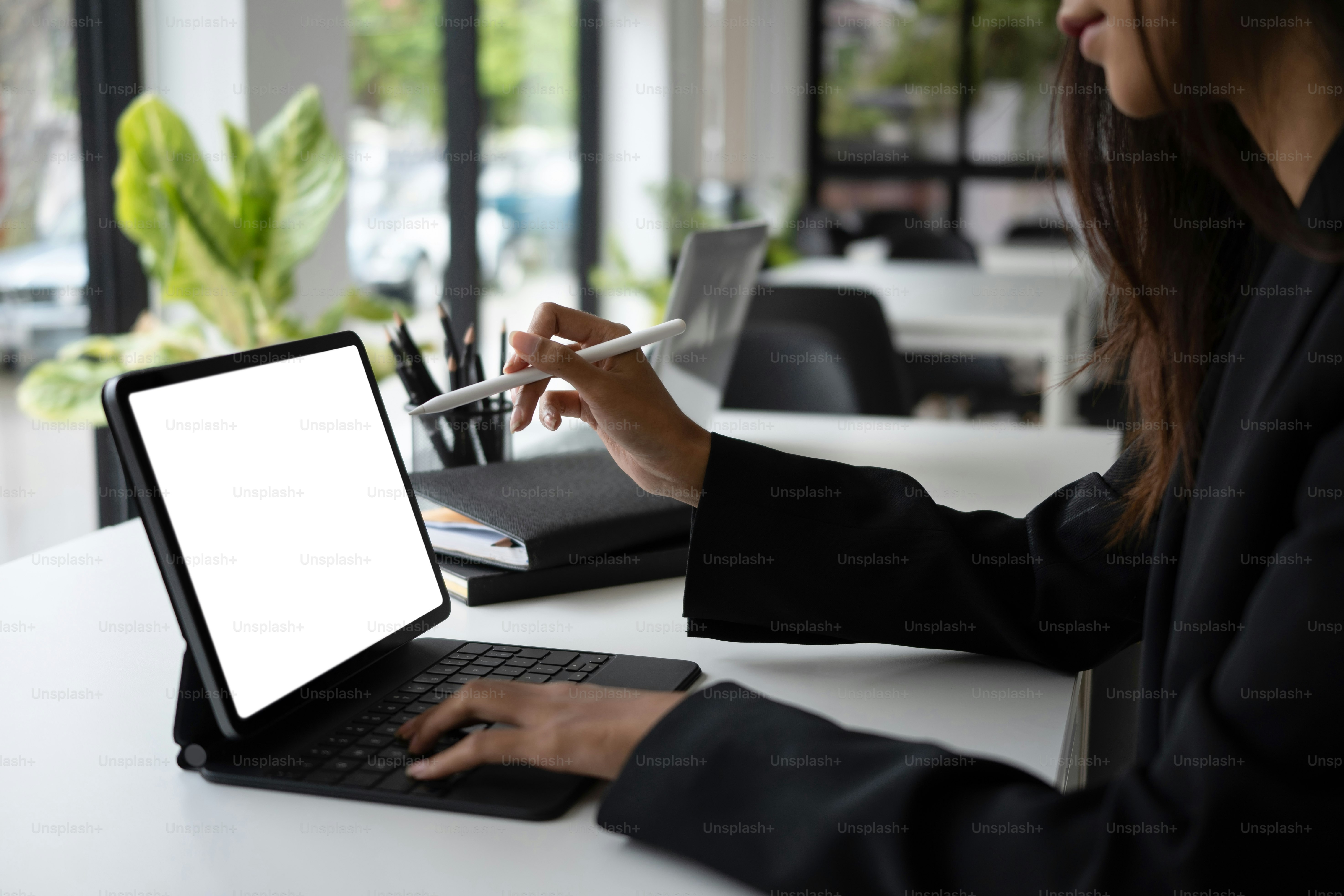 Plan recadré d’une femme d’affaires assise dans une salle de réunion et utilisant une tablette d’ordinateur.