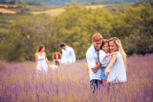 Large group of people in lavender field. Focus is on foreground.