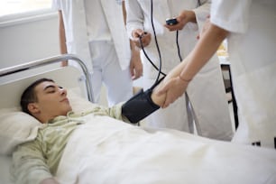 Take a blood pressure. Doctor taking man's blood pressure. Focus is on hands.