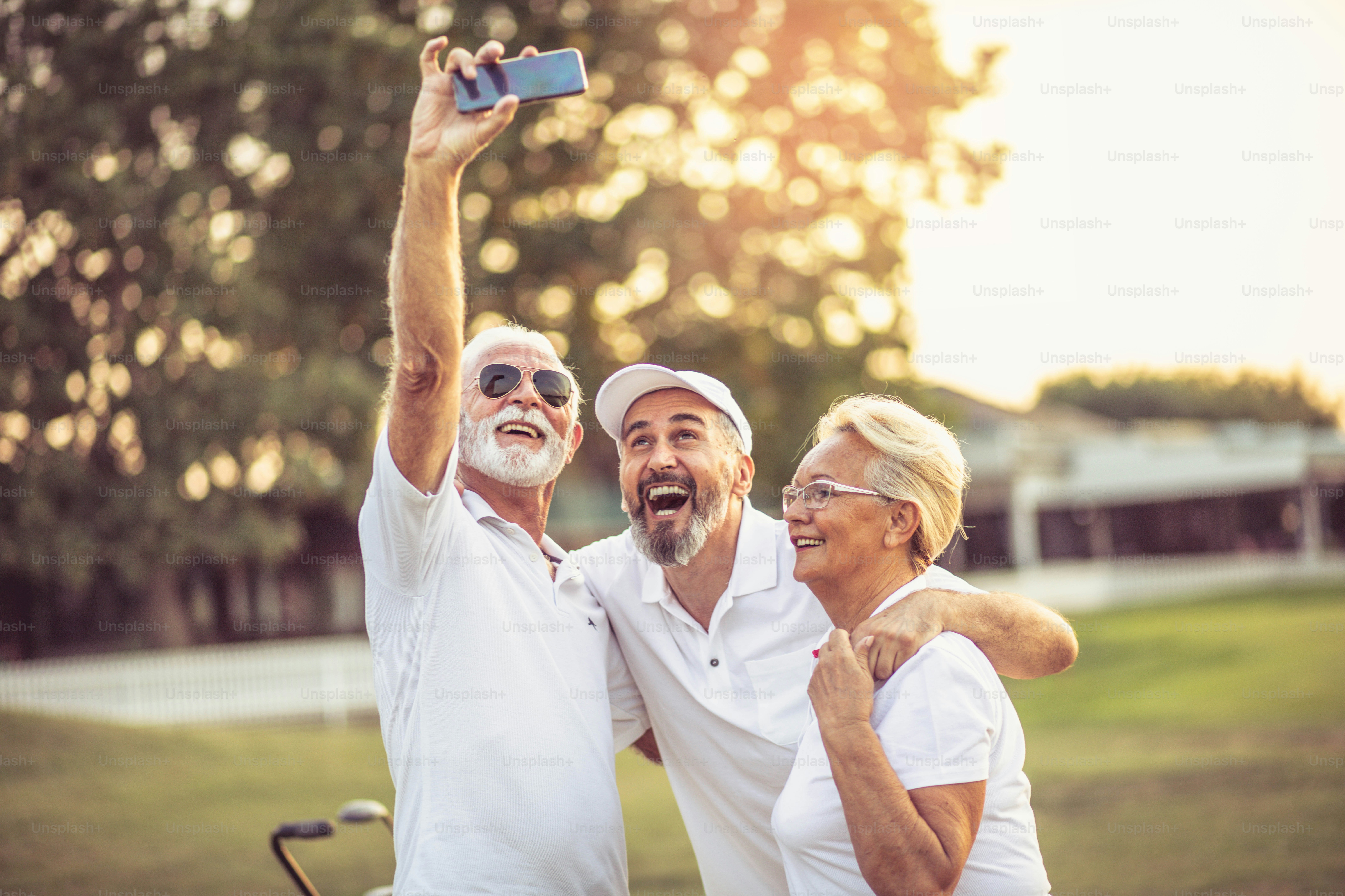 Senior golfers using phone and taking self portrait
