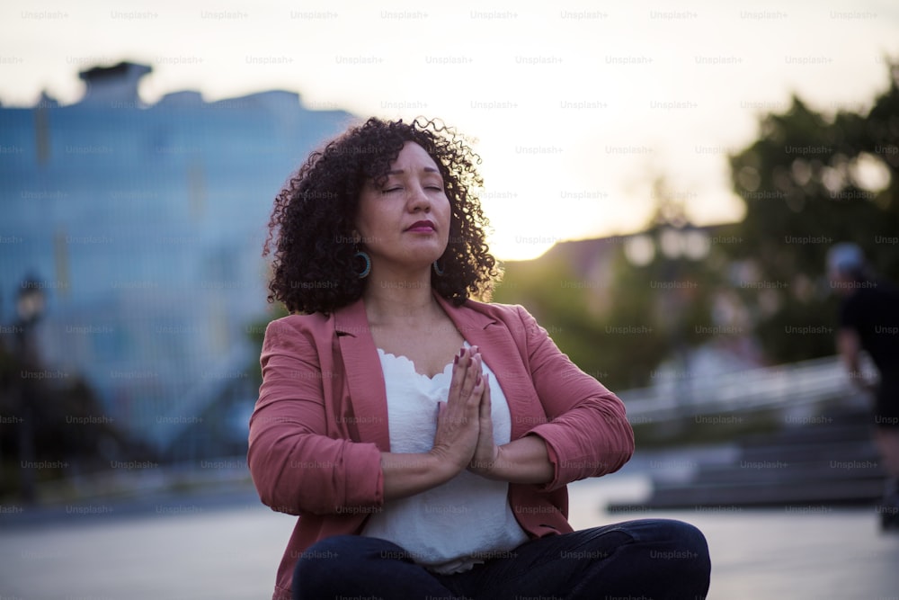 Time for some peace.  Business woman working yoga on the street.