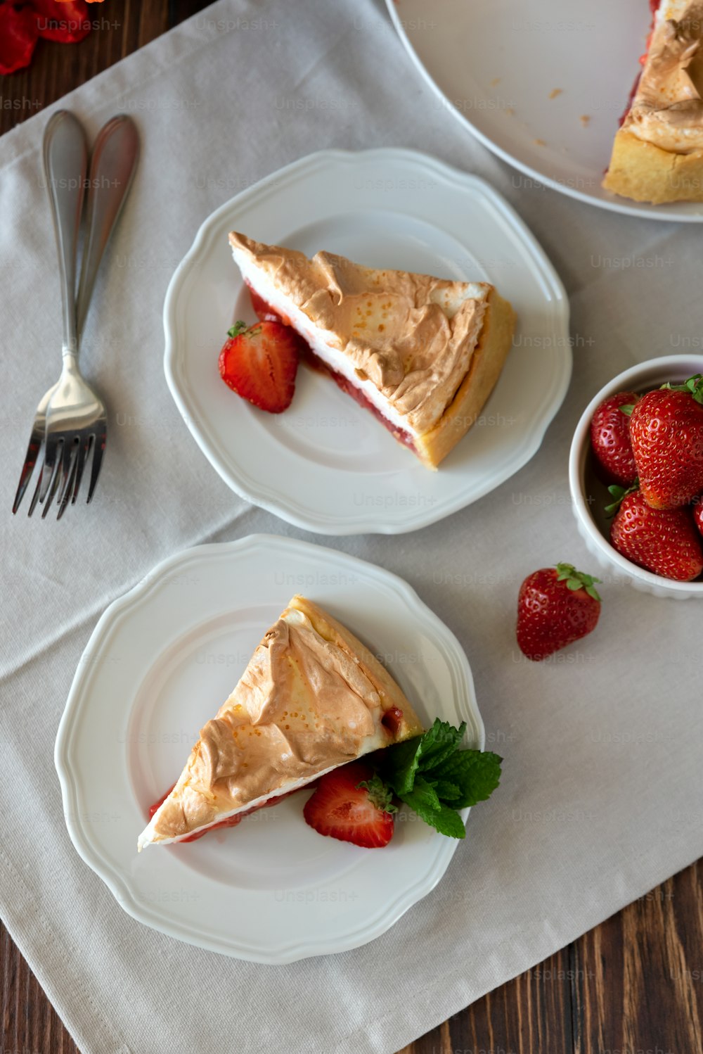 Slice of delicious strawberry tart with meringue on wooden background. Summer food. Top view