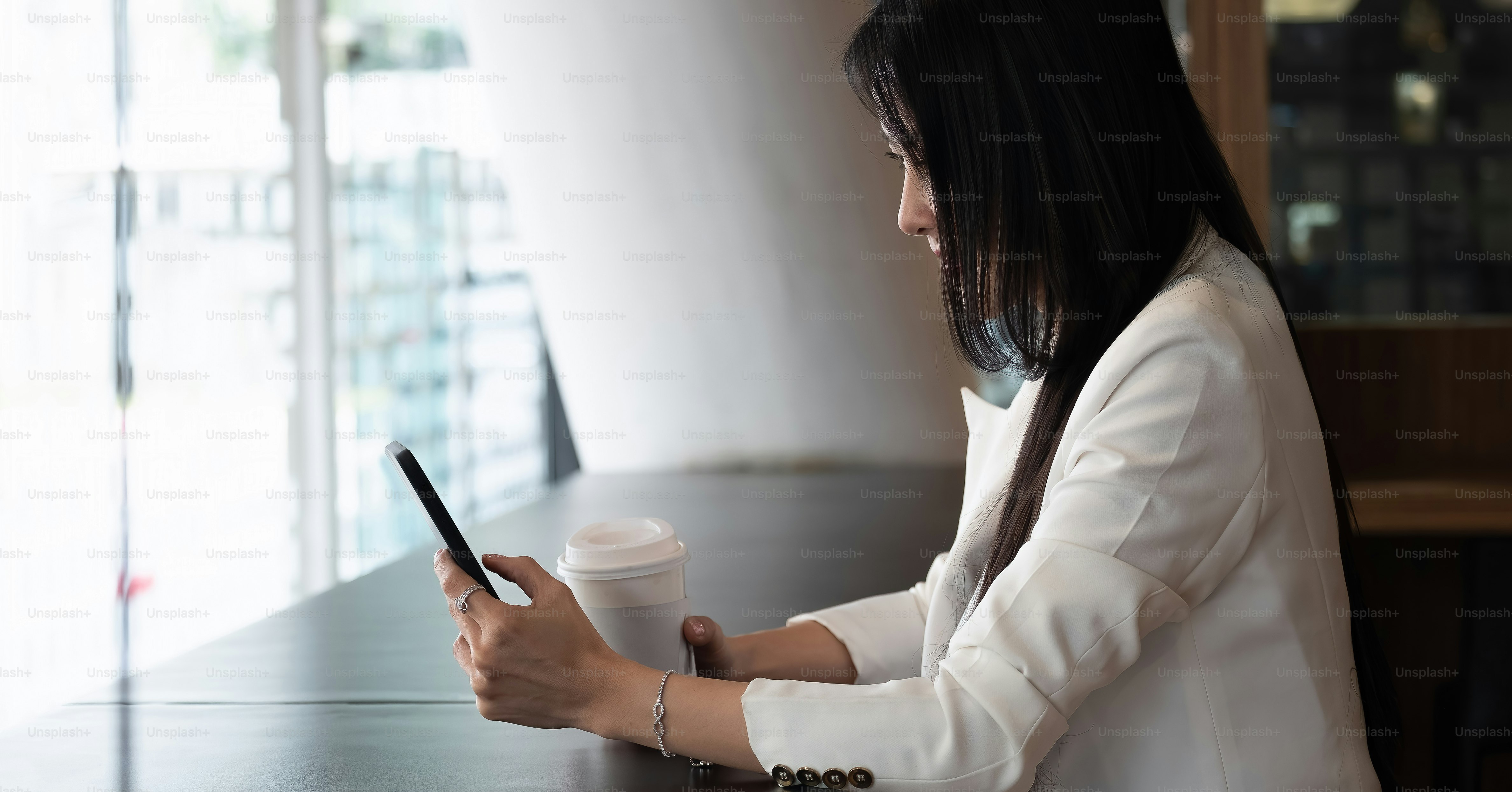 Shot of businesswoman using smartphone for video calling during working ...