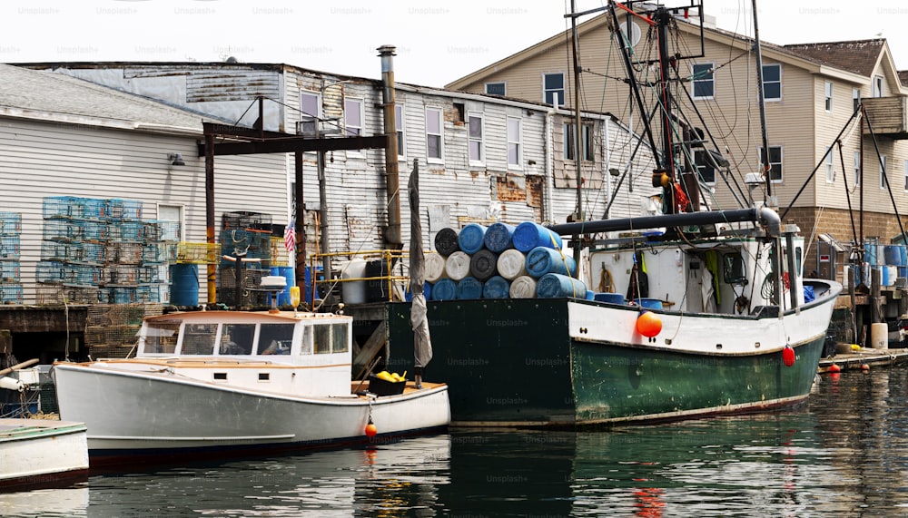 Commercial fishing boats docked behind buildings with colorful lobster traps, rope and everything they need to be ready to return to the sea the next day.