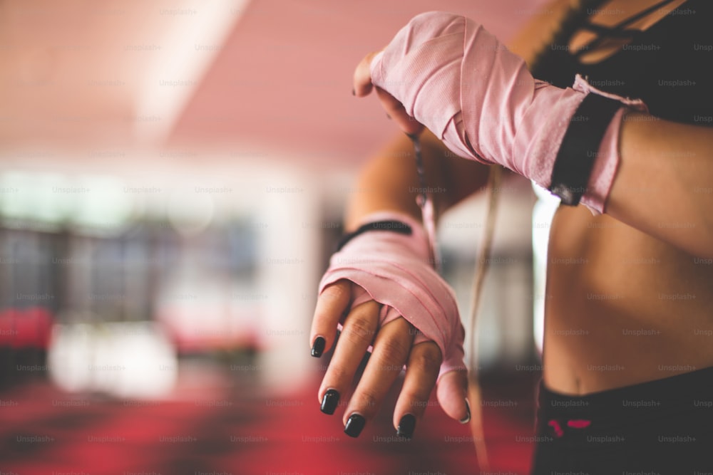 Woman with boxing gloves. Close up. Focus is on hands.