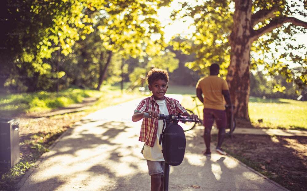 공원에서 전자 스쿠터를 탄 어린 소년.